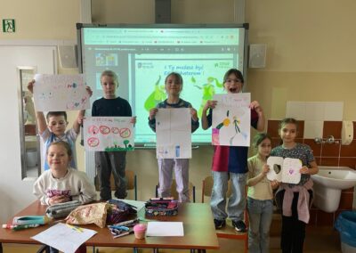 Grupa dzieci ustawiona do zdjęcia, każde trzyma plakat proekologiczny.